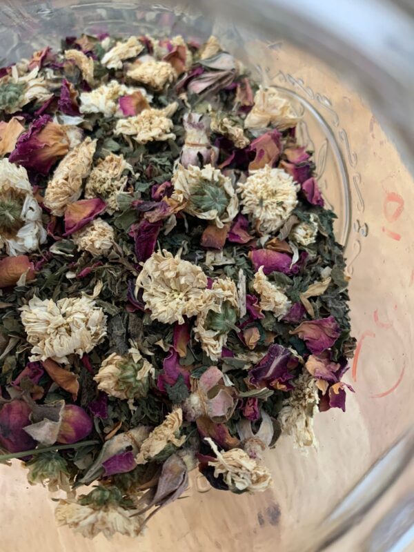 Image of chrysanthemums, rose and other Pitta tea ingredients in a glass jar